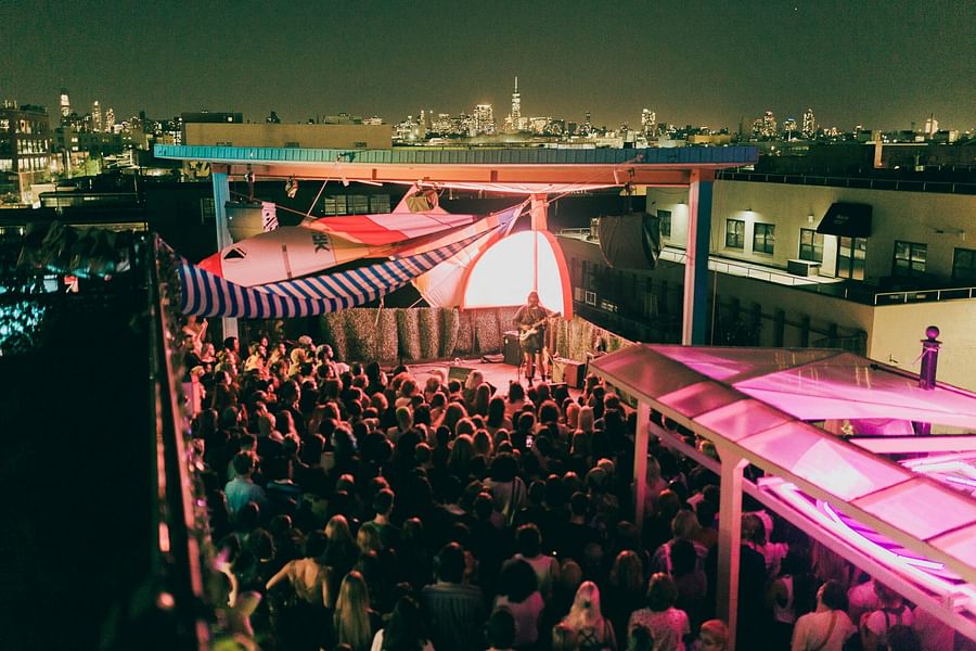 Brooklyn rooftop with art installations and cultural event against the NYC skyline